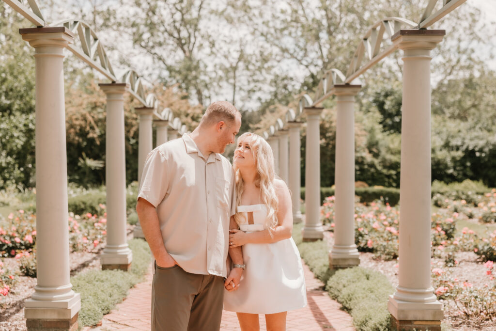 Alexa and Jacob share a joyful laugh amidst the beautiful scenery of Meadowbrook Hall, epitomizing their happiness and love during their engagement session