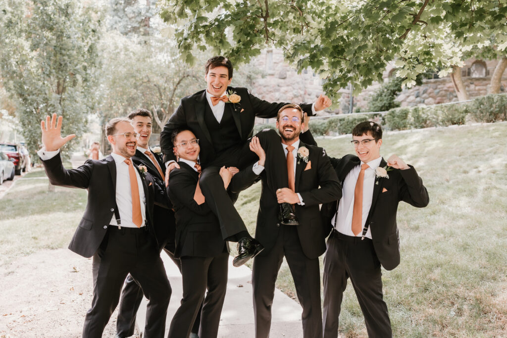Groom and groomsmen having fun at wedding