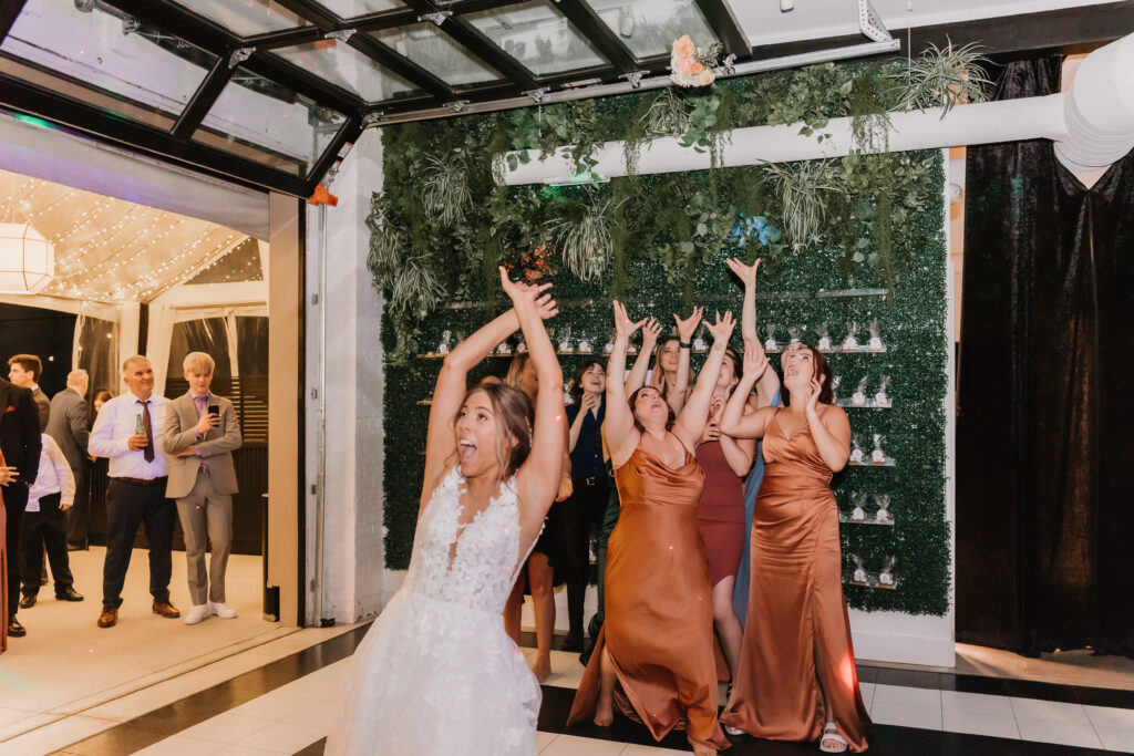 Bride tossing wedding bouquet at Michigan wedding, The Collins Off Main, Chelsea, Ann Arbor